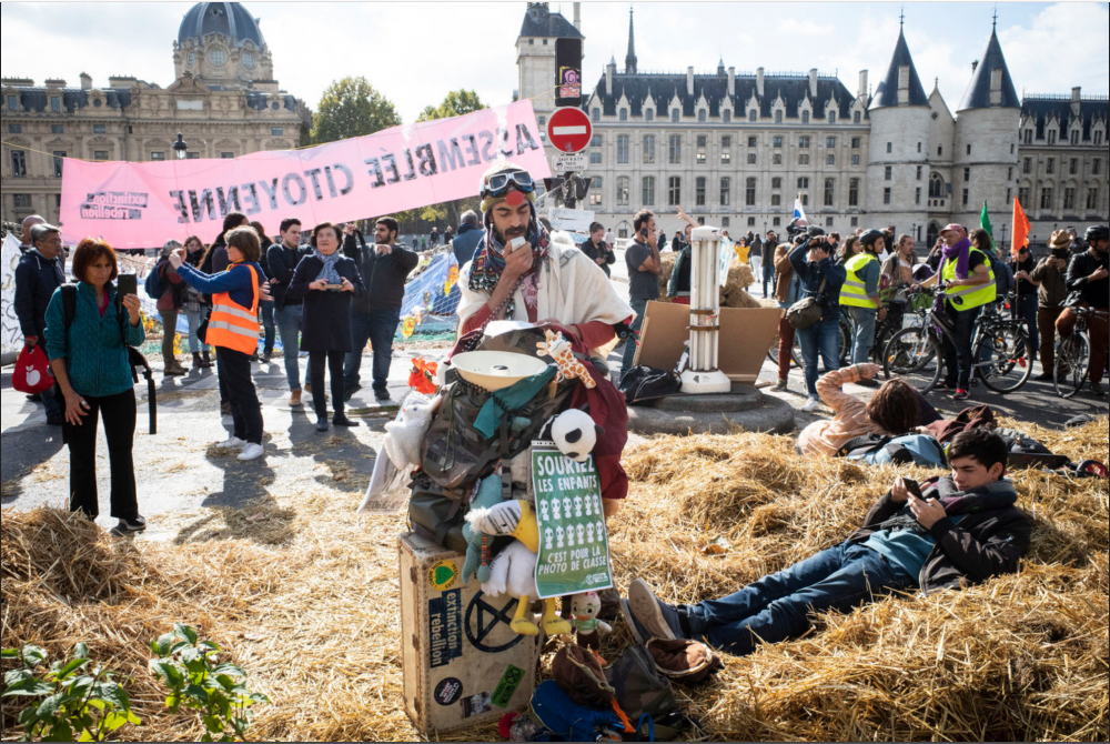 Exctinction rébellion | Photo prise lors du blocage de la place du chatelet lors de la RIO en 2019, une mini zad temporaire, des assemblées citoyennes, des ateliers de permacultures...